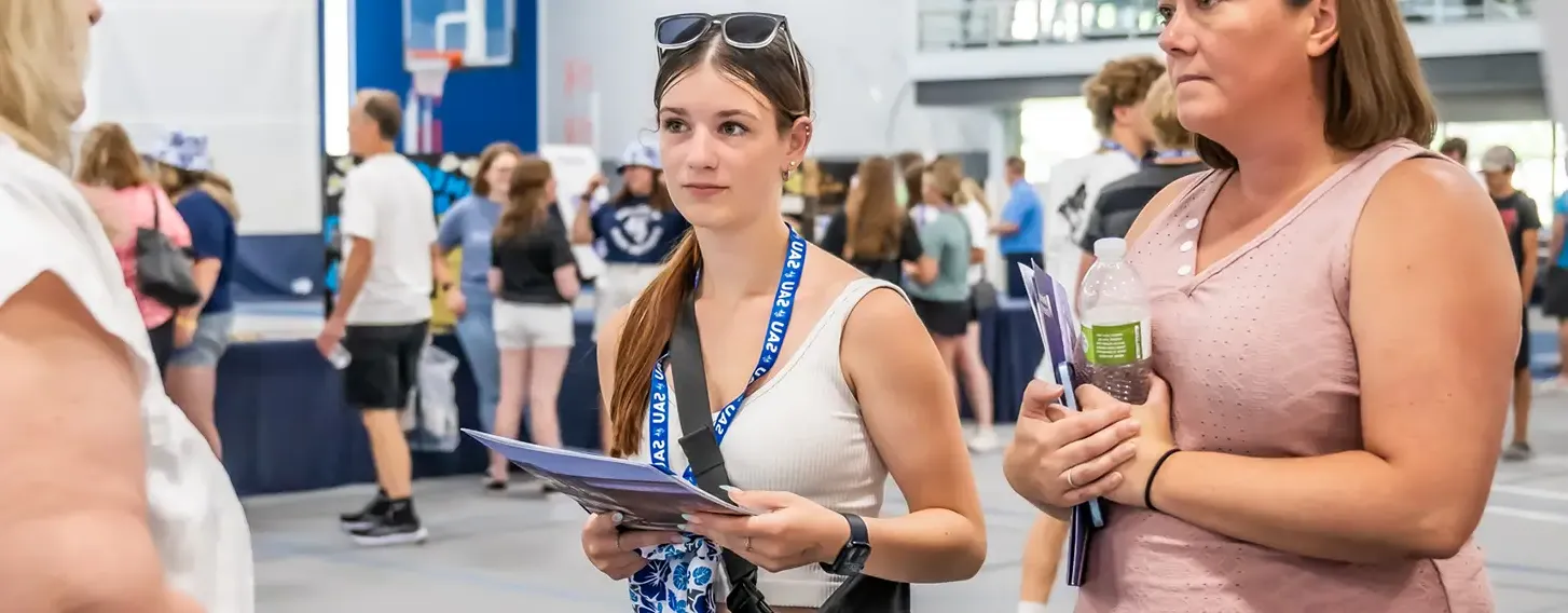 A student and a parent at a informational fair inside